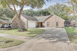 a brick house with a tree and a driveway at Houston Home with Screened Porch, Near Sugar Land! in Houston