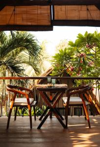 a table and chairs on a patio with palm trees at Hani Hideaway in Gili Air
