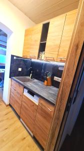 eine Küche mit einer Spüle und Holzschränken in der Unterkunft Ferienwohnungen Haus Marienblick in Berchtesgaden