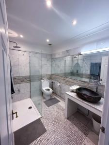 a bathroom with a sink and a toilet and a shower at Homestay - En-suites in New Malden