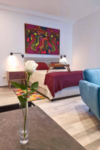 a bedroom with a bed with a vase with a flower at City Life Rijeka in Rijeka