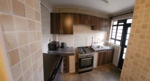 a small kitchen with a stove and a sink at Delight Stays in Thika