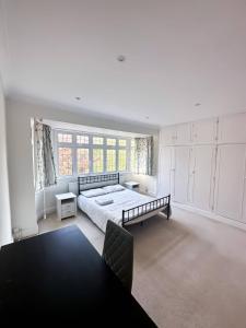 a large bedroom with a bed and a large window at Homestay - En-suites in New Malden