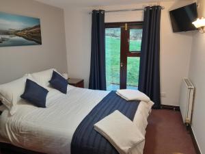 a bedroom with a bed with blue pillows and a window at Ye Olde Bowling Green Inn in Bradwell