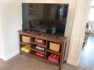 a flat screen tv sitting on a wooden entertainment center at Bike in Bike out Coler The Trail House in Bentonville