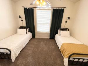 two beds in a room with a window at Bike in Bike out Coler The Trail House in Bentonville