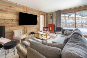a living room with a couch and a flat screen tv at Chalet La Turra, Spa privée in Lanslebourg-Mont-Cenis
