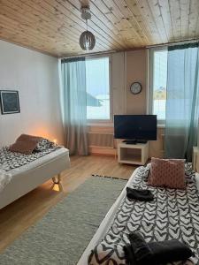 a bedroom with two beds and a flat screen tv at Apartment Isokatu2 in Kokkola