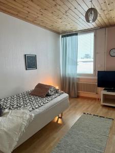 1 dormitorio con cama, ventana y TV en Apartment Isokatu2, en Kokkola