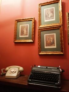 a desk with a keyboard and a telephone and framed pictures at Casa rural de la Abuela in Cadreita