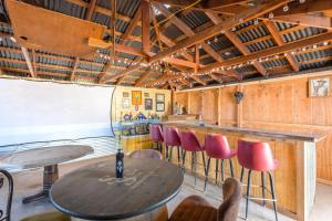 a bar with wooden walls and tables and red chairs at Tombstone History & Cozy Cabin Glamping Stay in Tombstone