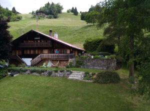uma casa numa colina com um jardim verde em Chalet Beau Site em Le Sépey
