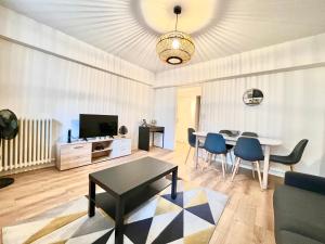 uma sala de estar com uma mesa e cadeiras azuis em Stay house to Poitiers em Poitiers