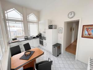 una cocina con mesa y sillas y un reloj en la pared en Ferienwohnung Bülowstraße, en Heringsdorf
