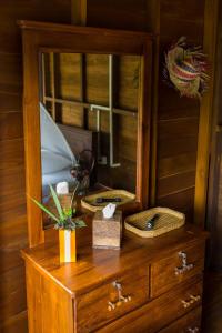 a wooden cabinet with a mirror on top of a dresser at Wanakaset Forest Glamping in Kitulgala