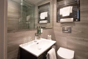 een badkamer met een wastafel, een toilet en een spiegel bij Windermere Rooms at The Wateredge Inn in Ambleside