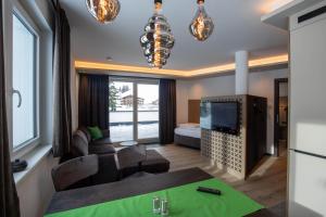a living room with a couch and a tv at Place2be in Ischgl