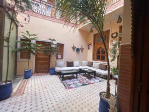 a living room with a couch and palm trees at Riad Jenan Adam in Marrakesh