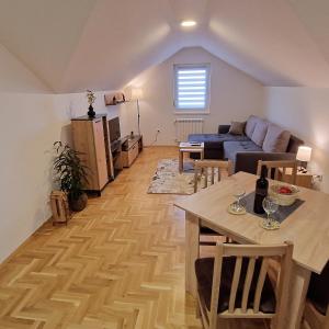 Stan na dan Apartman S في بوزاريفاتش: غرفة معيشة مع طاولة وأريكة