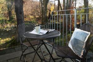 a table and chairs with a cup of coffee on it at The Windermere Rooms at The Wateredge Inn, Ambleside in Ambleside