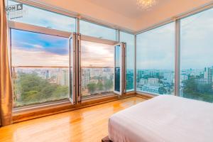 a bedroom with a bed and large windows at Son&Henry Sailing Tower in Ho Chi Minh City