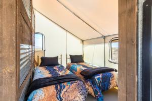 two beds in the inside of a tent at Silver Spur Homestead Luxury Glamping -The Miner in Tombstone