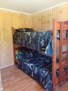 Zimmer mit 2 Etagenbetten und einem Sofa in der Unterkunft Cabañas Lomas de Putagan in Linares