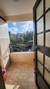 een uitzicht vanaf het balkon van een kamer met een deur bij Delight Stays in Thika