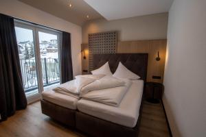 a bedroom with a bed with a large window at Place2be in Ischgl