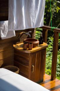 y baño con lavabo sobre una mesa de madera. en Wanakaset Forest Glamping, en Kitulgala