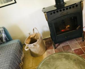 a living room with a fireplace and a bag at ROUGE COTTAGE Gîte 4 étoiles Billard in Gueutteville-les-Grès