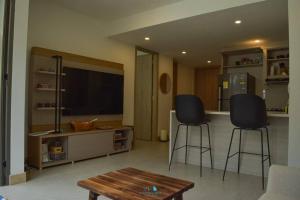 sala de estar con 2 taburetes y TV de pantalla plana en Apartamento en Cartagena - Morros Zoe, en Cartagena de Indias