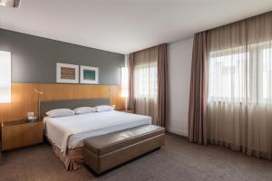 a bedroom with a bed and a large window at DELPLAZA Marabá São Paulo in São Paulo