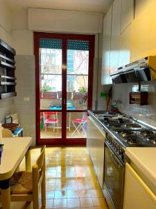 a kitchen with a stove and a table and a window at -Secret View - Marina di Carrara in Carrara