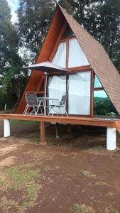 a small house with two chairs and a roof at Cabañas Keikary in Valle de Bravo