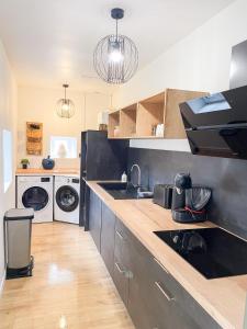 eine Küche mit einer Spüle und einer Waschmaschine in der Unterkunft Maison spacieuse et chaleureuse in Condé-sur-Sarthe