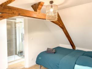 ein Schlafzimmer mit einem blauen Bett und einem Kronleuchter in der Unterkunft Maison spacieuse et chaleureuse in Condé-sur-Sarthe
