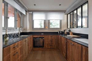 a kitchen with wooden cabinets and black counter tops at Les 2 chalets - Les appartements du Strato in Courchevel
