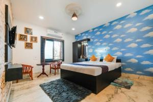 een slaapkamer met een bed met wolken op de muur bij Royal Adwita Resort in Cuttack