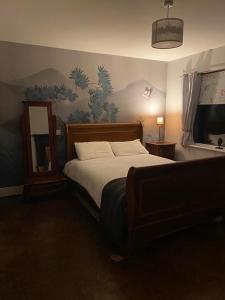 a bedroom with a bed and a painting on the wall at LOCH CONNELL LODGE in Letterkenny