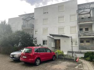 un coche rojo estacionado frente a un edificio en Appartio: Studio-Appartement am Stadtrand en Kornwestheim