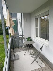 einen Balkon mit einem Tisch und Stühlen sowie einem Fenster in der Unterkunft Appartio: Studio-Appartement am Stadtrand in Kornwestheim