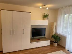 a living room with a tv and a large white cabinet at Appartio: Studio-Appartement am Stadtrand in Kornwestheim
