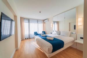 a bedroom with a large bed and a large window at P A N O R A M A ORBi city APARTHOEl SEA VIEW in Batumi