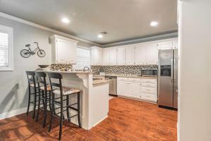 a kitchen with white cabinets and a counter with bar stools at ROYAL LANDING 3BD MTB Friendly in Bentonville