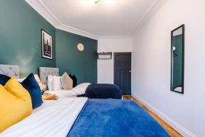 een slaapkamer met 2 bedden en een muur met blauwe accenten bij Huge House in Leeds 6BR sleeps13 by PureStay Short Lets in Meanwood