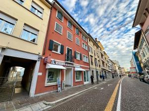 a street with buildings and people walking down the street at Appartamento con terrazzo in Udine