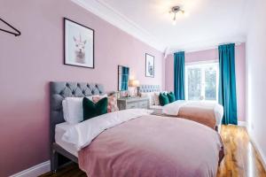 twee bedden in een slaapkamer met roze muren en blauwe gordijnen bij Huge House in Leeds 6BR sleeps13 by PureStay Short Lets in Meanwood