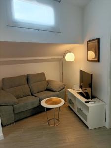 sala de estar con sofá y mesa con TV en Apartamento Gran Vía Madrid W2, en Madrid