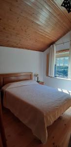 um quarto com uma cama grande e uma janela em Casa do Loureiro em Arganil